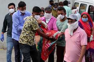 Familiares llevan a una mujer que se desmayó después de ver el cuerpo de su esposo en un hospital gubernamental COVID-19 en Ahmedabad, India, el martes 27 de abril de 2021. Los casos de coronavirus en India están aumentando más rápido que en cualquier otro lugar del mundo. Foto: AP / Ajit Solanki.