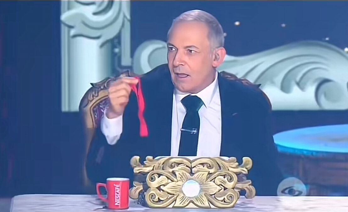 Yo me llamo Alejandra Guzmán le entrega un liguero rojo a César Escola en medio de su presentación.