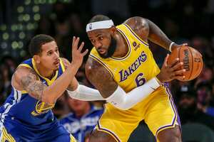 Los Angeles Lakers forward LeBron James, right, is defended by Golden State Warriors forward Juan Toscano-Anderson during the second half of a preseason NBA basketball game in Los Angeles, Tuesday, Oct. 12, 2021. (AP Photo/Ringo H.W. Chiu)