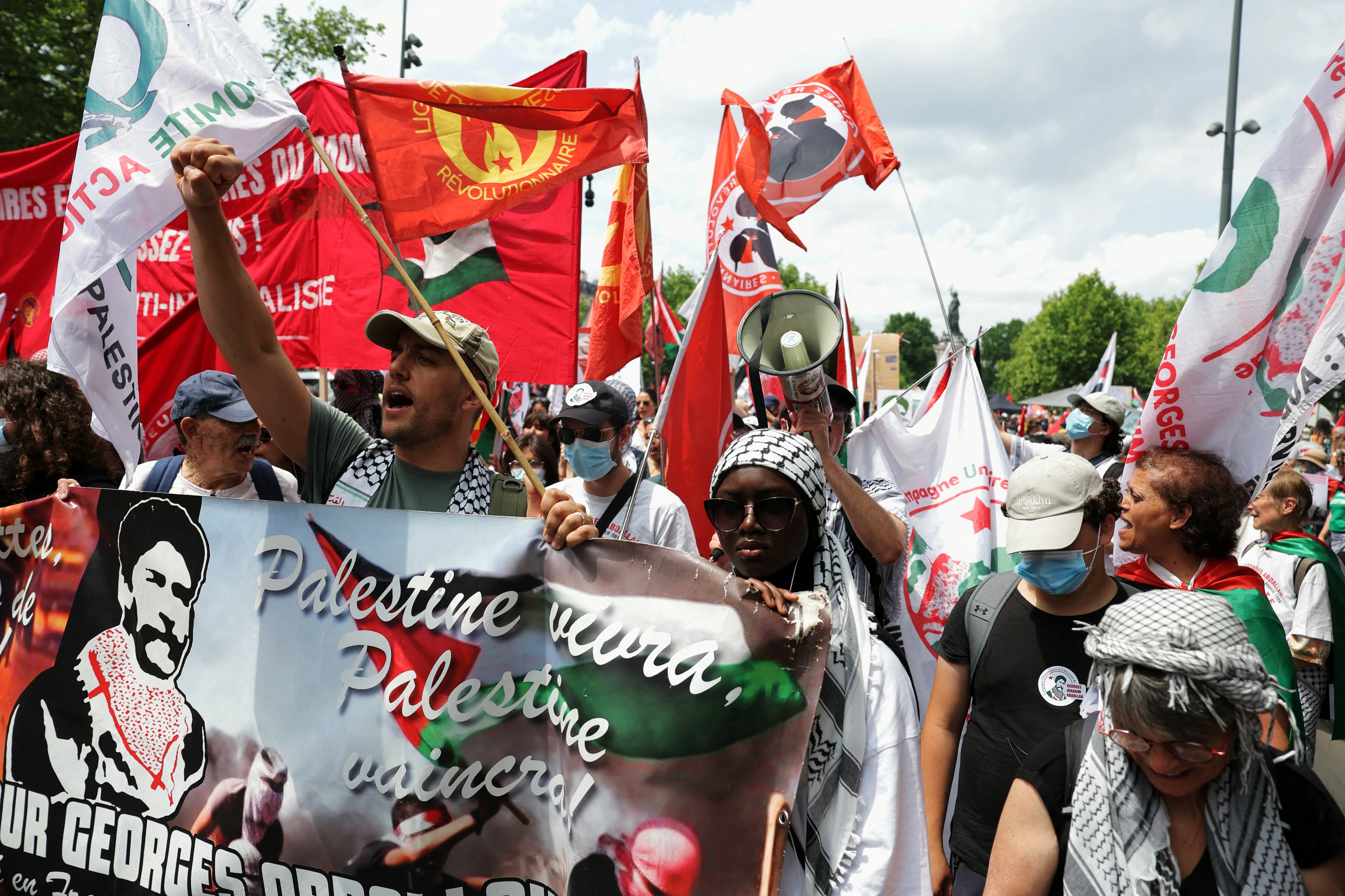 Protesters march behing a banner during a pro-Palestinian demonstration called by several French unions at the Place de la R�publique in Paris on June 14, 2025. French Democratic Confederation of Labour trade union (CFDT), French trade union General Confederation of Labour (CGT), French National Union of Autonomous Trade Unions (Unsa) Unsa, French group of trade unions Union syndicale Solidaires (SUD) and French trade union "Federation Syndicale Unitaire" (FSU) are calling for people to join "the mobilisation for Palestine" on June 14, 2025 and denounce "the Israeli authorities mortifying headlong rush and the atrocities" in Gaza, according to a joint statement. (Photo by Thomas SAMSON / AFP)