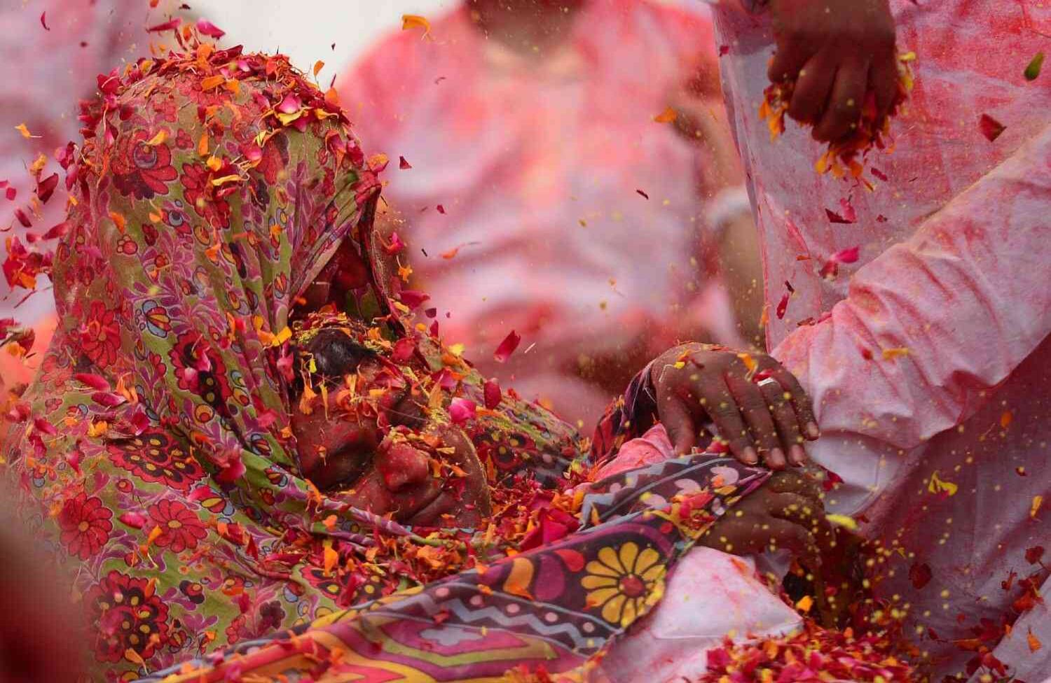 Los pétalos de flores y los polvos de colores se arrojan en un evento para celebrar el festival hindú de Holi para niños con parálisis cerebral organizado por la Fundación Trishla en Allahabad el 25 de febrero de 2018. SANJAY KANOJIA / AFP