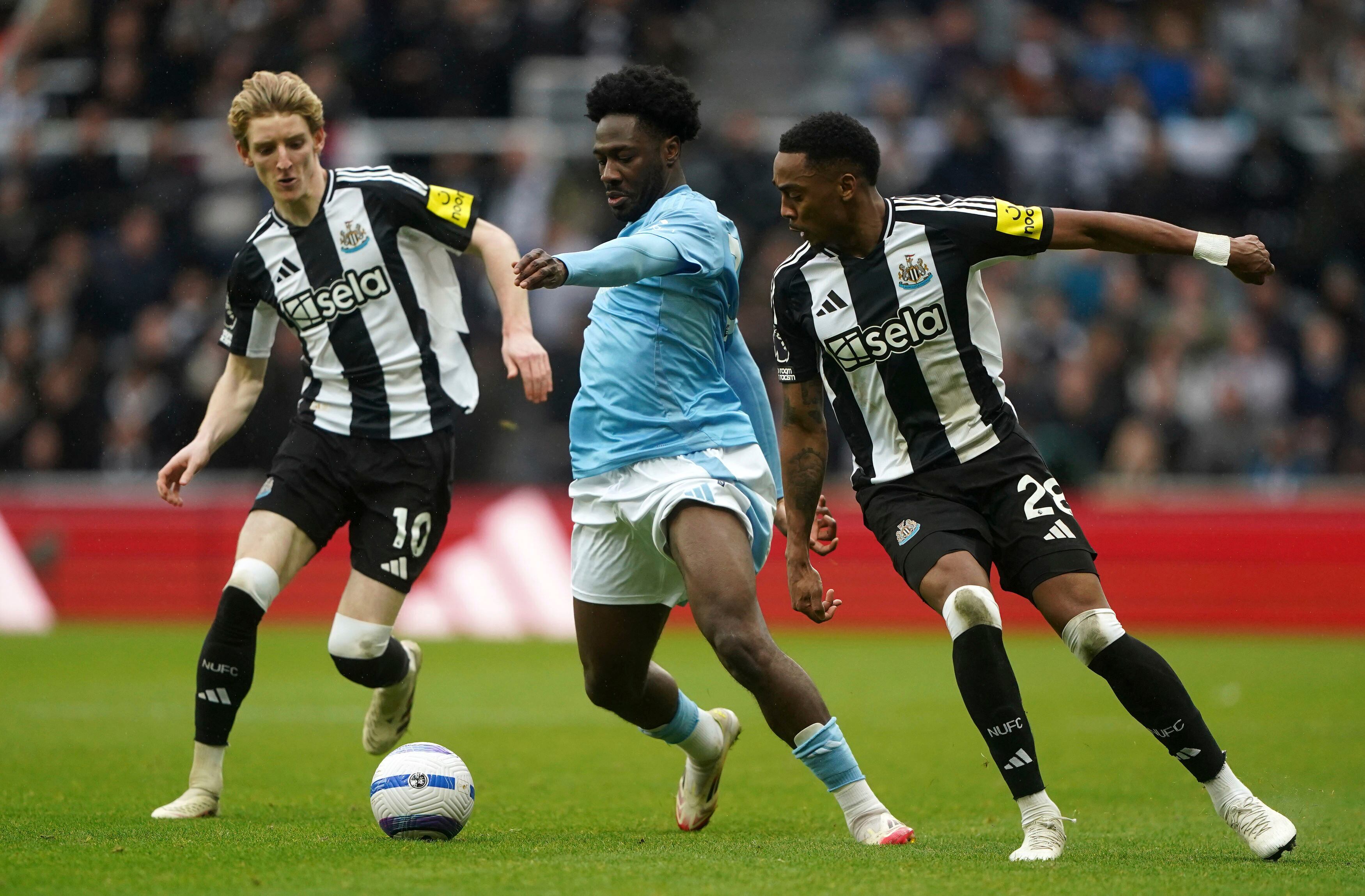 Nottingham Forest's Ola Aina is challenged by Newcastle United's Joe Willock, right, and Anthony Gordon during the English Premier League soccer match between Newcastle United and Nottingham Forest at St James' Park, Newcastle upon Tyne, England, Sunday, Feb. 23, 2025. (Owen Humphreys/PA via AP)