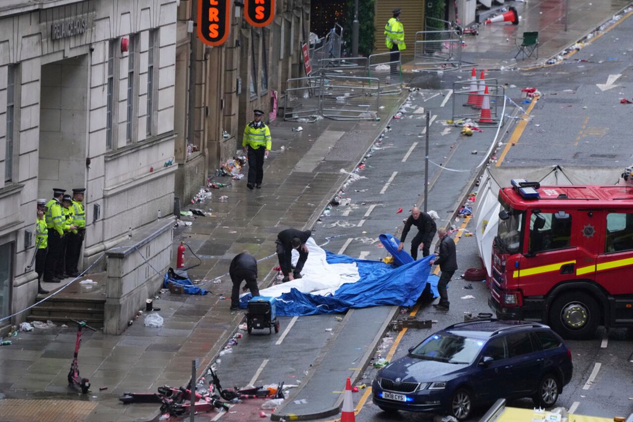 La policía y el personal de emergencia lidian con un incidente después de que un automóvil chocara con peatones cerca del Liver Building durante el desfile de ganadores de la Premier League en Liverpool, Inglaterra, el lunes 26 de mayo de 2025. (Foto AP/Jon Super)