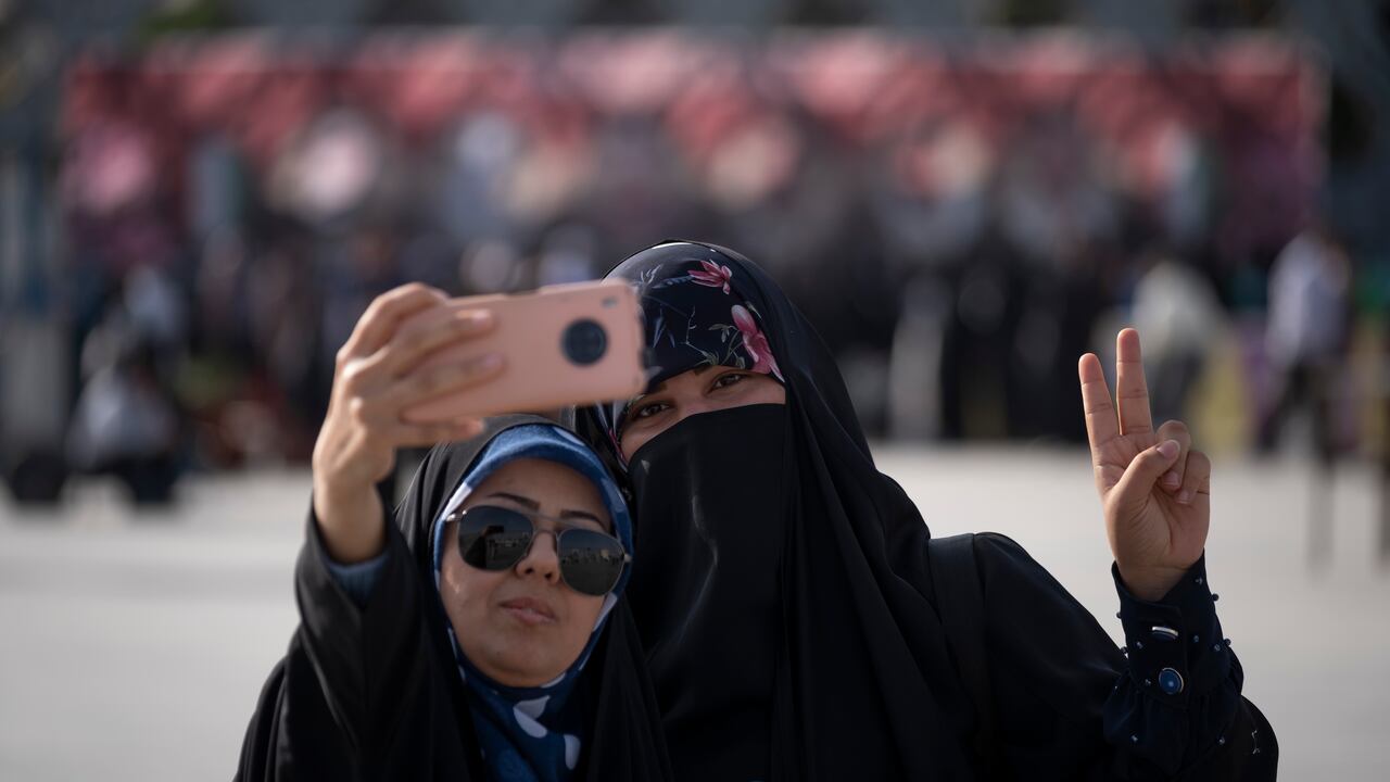 Una mujer iraní con velo hace un signo de victoria mientras se toma un selfie durante una manifestación en apoyo del Hijab y contra las mujeres que no usan el Hijab obligatorio, en el sur de Teherán, el 12 de julio de 2023.