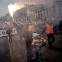 Un hombre carga a un niño y saluda con una antorcha mientras miles de personas se reúnen en el centro de la ciudad para una marcha anual del Día de la Independencia organizada por grupos nacionalistas que ha estado marcada por la violencia en los últimos años en Varsovia, Polonia, el viernes 11 de noviembre de 2019. 2022.