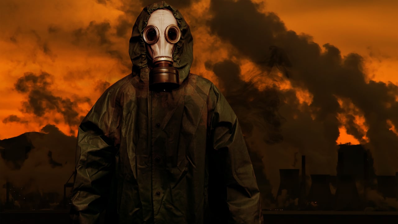 Persona con máscara de gas en escenario catastrófico.