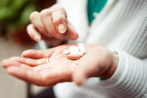 Senior woman holding pills selection in her hands, close-up.
