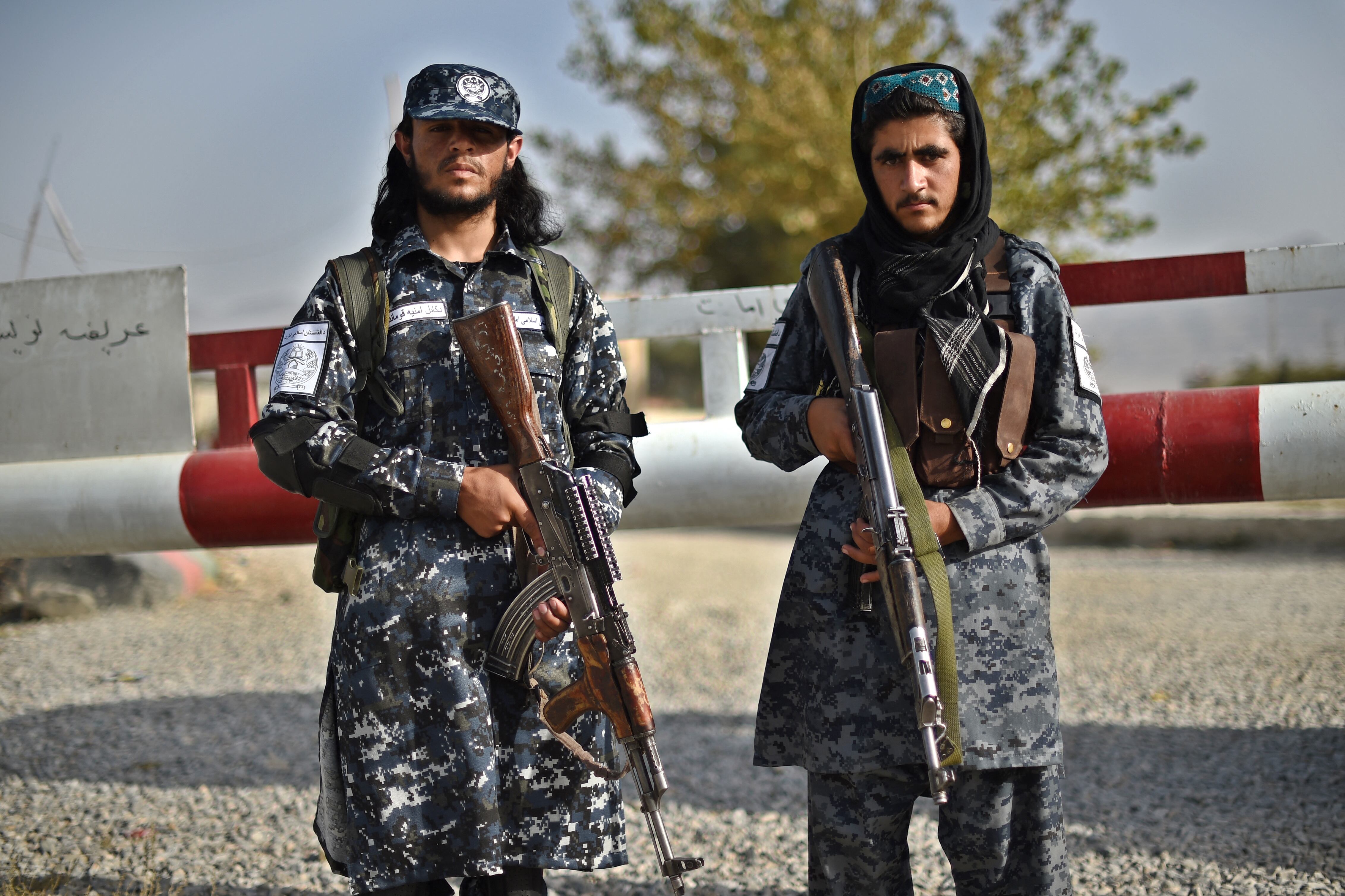 In this picture taken on October 3, 2021, Taliban fighters working as a police force stand guard at the entrance gate of a police district in Kabul. - The Taliban's new police force already counts about 4,000 men in the capital, says a Kabul police spokesman, insisting the city is far safer than before, as the hardline group builds a police force from scratch. (Photo by WAKIL KOHSAR / AFP) / TO GO WITH Afghanistan-police-Taliban,FOCUS by Elise BLANCHARD