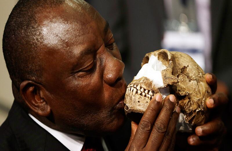 El vicepresidente de Sudáfrica, Cyril Ramphosa, besa la cara del nuevo antepasado del hombre: el Homo naledi, descubierto en la "Cuna de la Humanidad" ubicada en Maropeng.