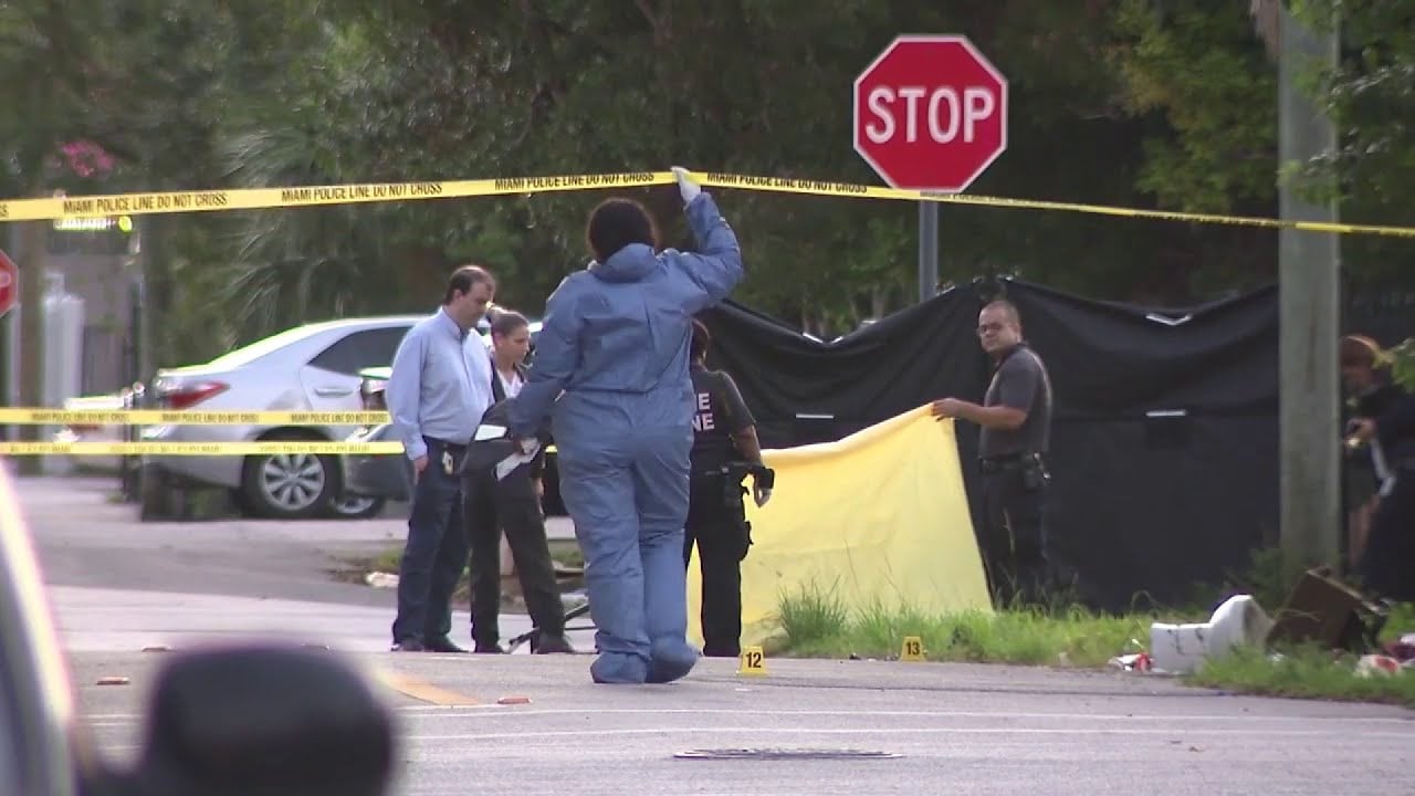 Peritos forenses recogen casquillos de bala en Little Haiti tras tiroteo mortal.