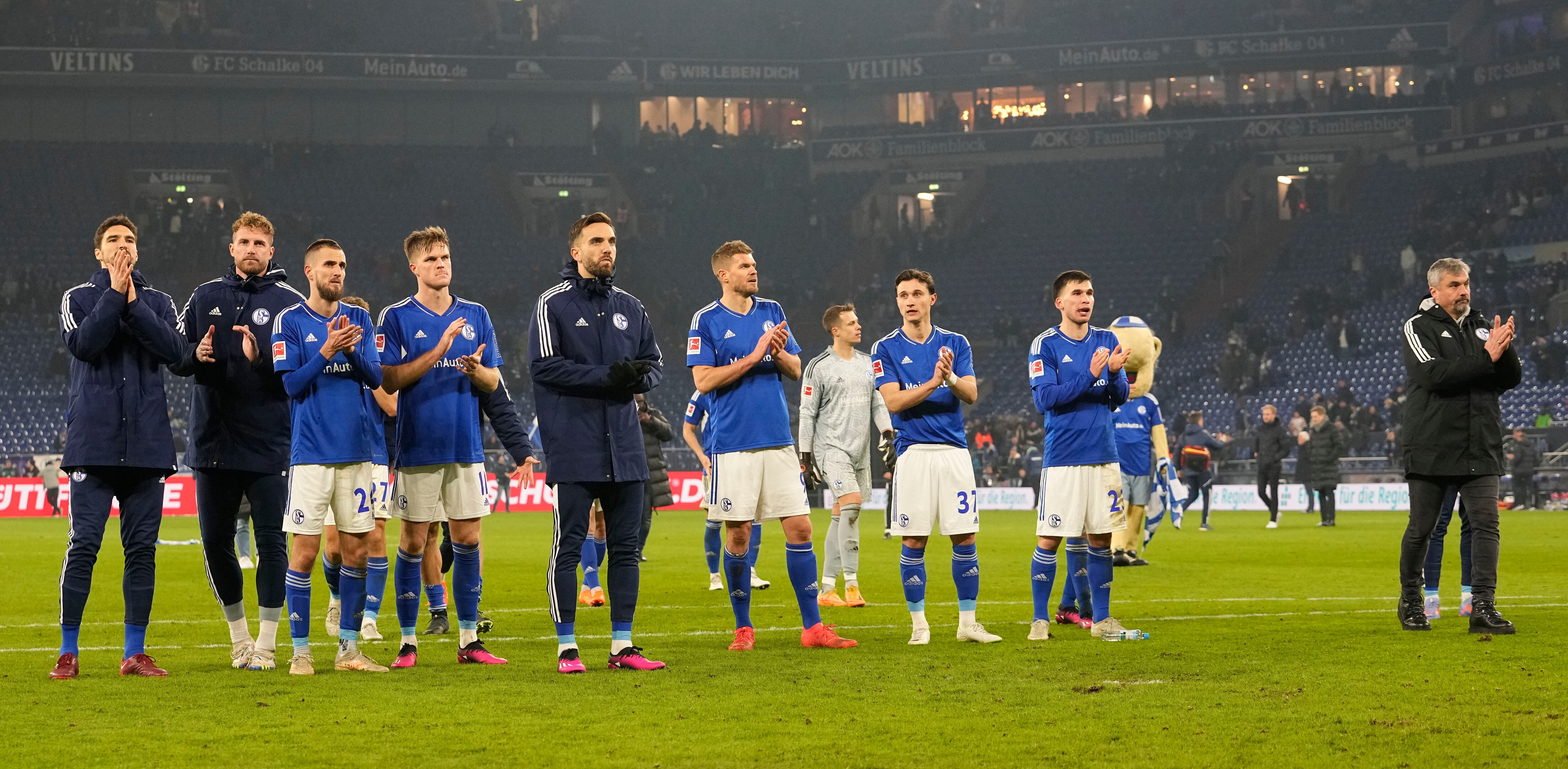 Schalke's head coach Thomas Reis, right, and his players walk to supporters after losing the German Bundesliga soccer match between FC Schalke 04 and RB Leipzig at the Arena in Gelsenkirchen, Germany, Tuesday, Jan. 24, 2023. (AP Photo/Martin Meissner)
