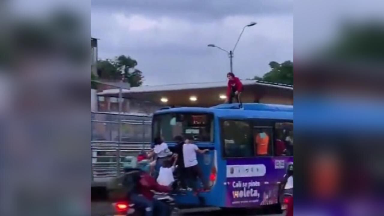 La mujer se trepó al techo y otros jóvenes se colgaron de la parte trasera del bus.