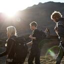 Tres mochileros caminando en zona de montaña.