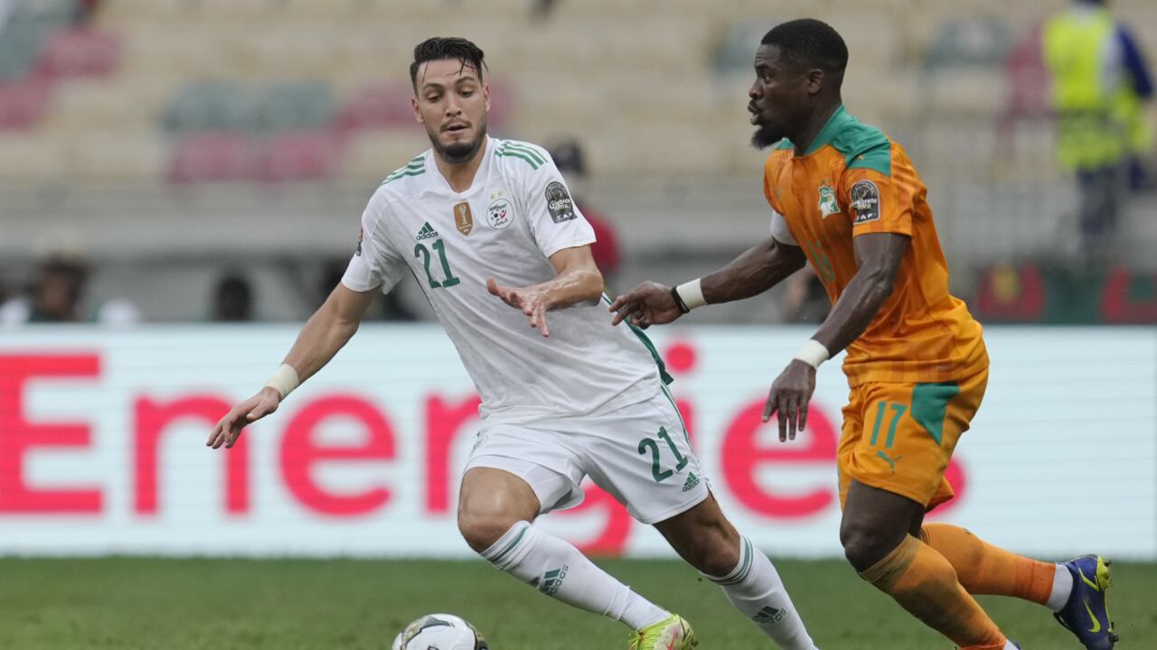 Ivory Coast's Serge Aurier, right, controls the ball as Algeria's Ramy Bensebaini watches on, during the African Cup of Nations 2022 group E soccer match between Ivory Coast and Algeria at the Japoma Stadium in Douala, Cameroon, Thursday, Jan. 20, 2022. (AP/Themba Hadebe)