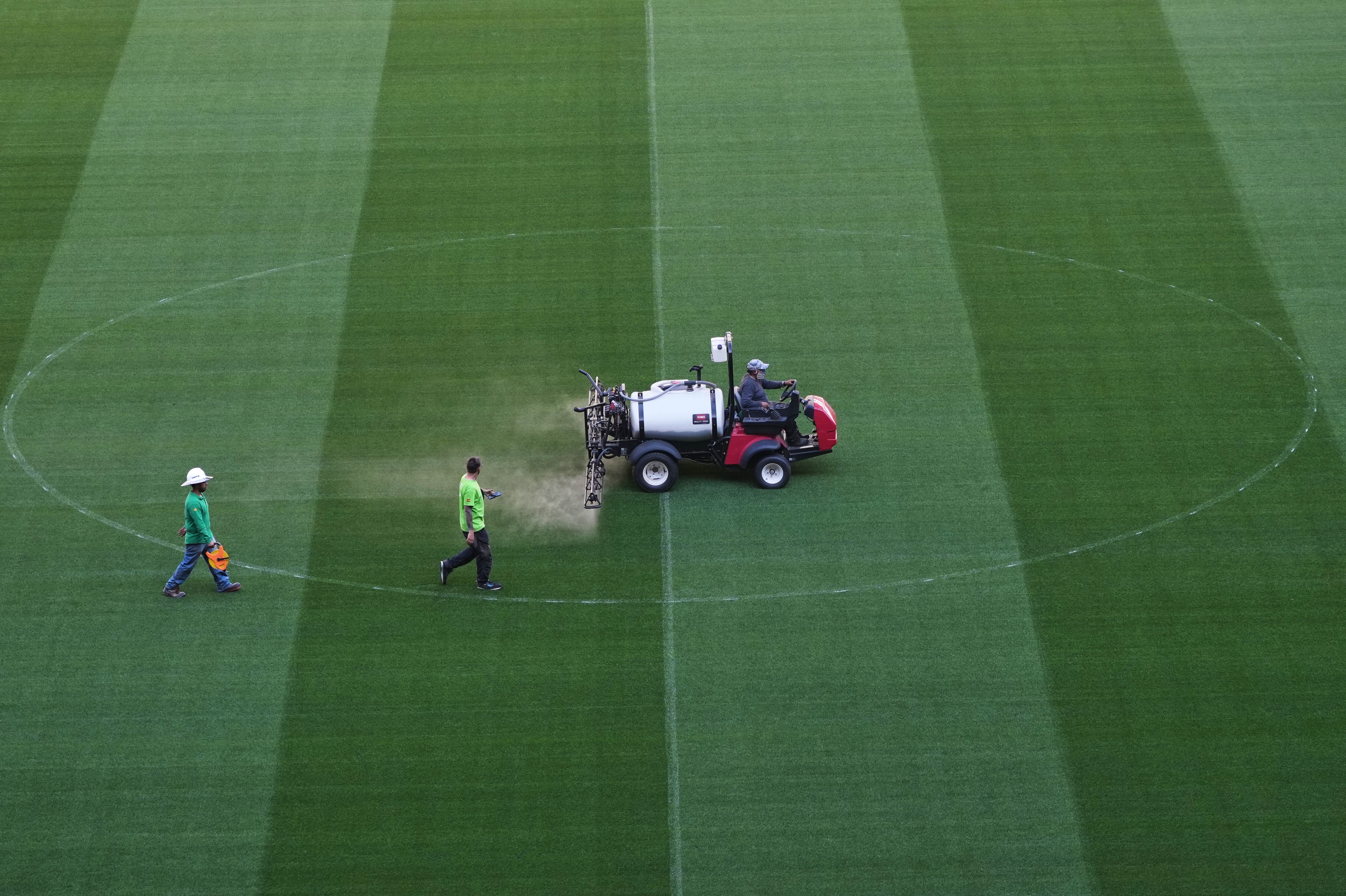 Trabajadores recorren el césped del Estadio Azteca durante una visita de prensa para mostrar las renovaciones previas al Mundial de 2026.