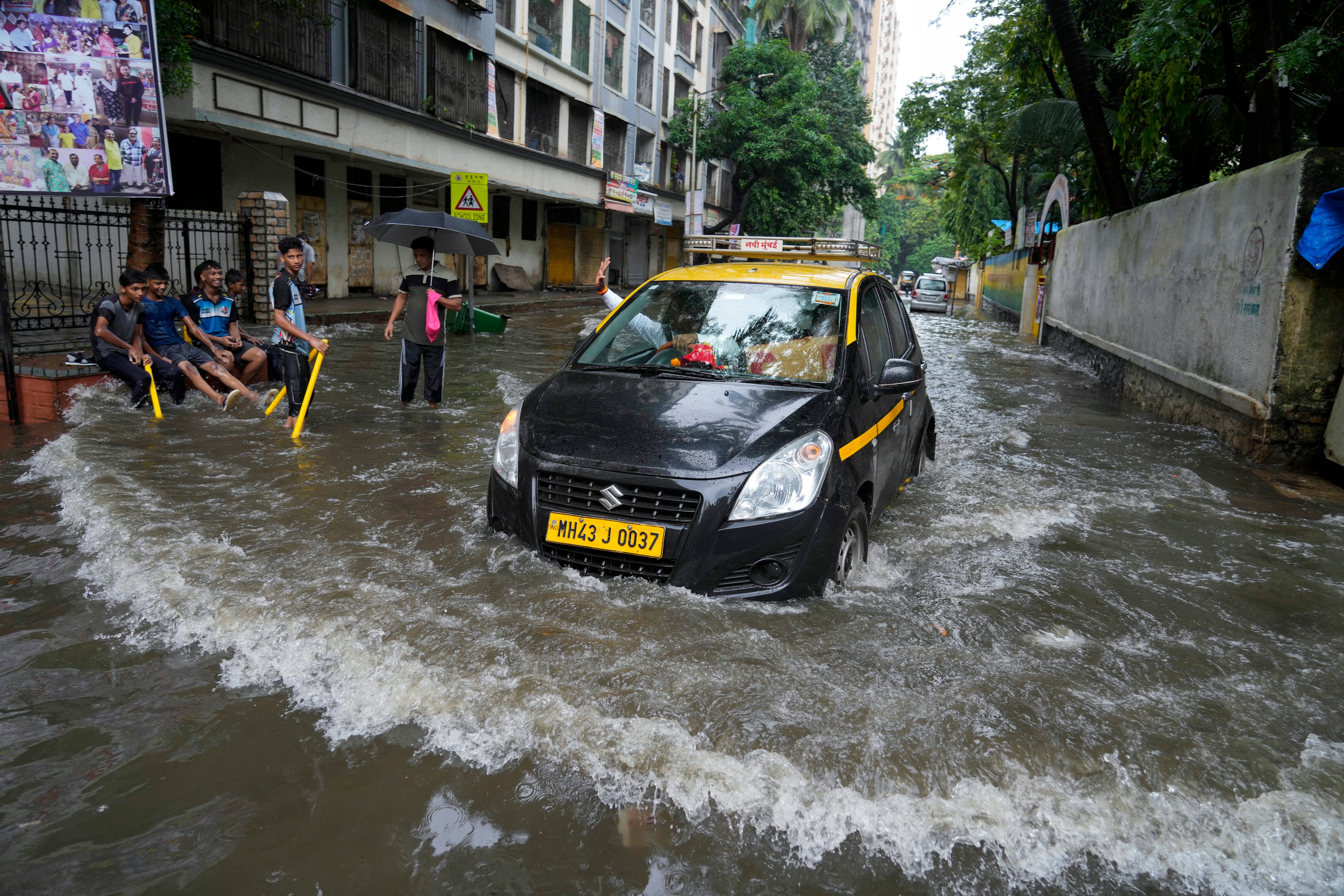 Un automóvil circula por una calle inundada después de fuertes lluvias en Mumbai, India, el lunes 8 de julio de 2024.