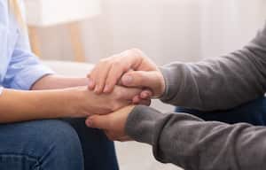 Psychiatrist councelling his patient hands during therapy