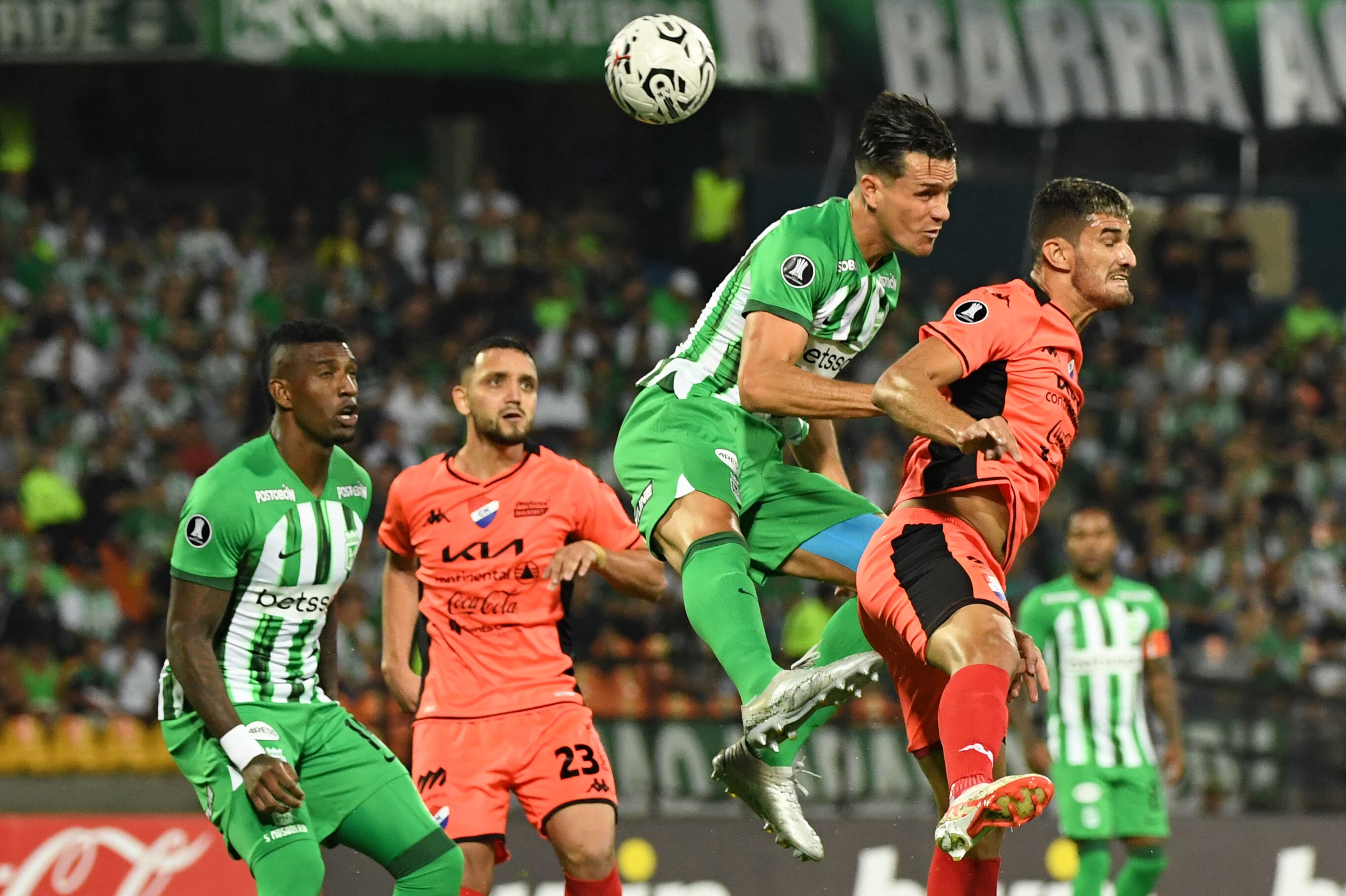 Bernardo Espinosa (2-R) del Atlético Nacional y el jugador de Nacional Rodrigo Arévalo (R) luchan por el balón durante el partido de vuelta de la segunda ronda de la Copa Libertadores entre el Atlético Nacional de Colombia y el Nacional de Paraguay en el estadio Atanasio Girardot de Medellín el 28 de febrero. 2024. (Foto de Jaime SALDARRIAGA/AFP)