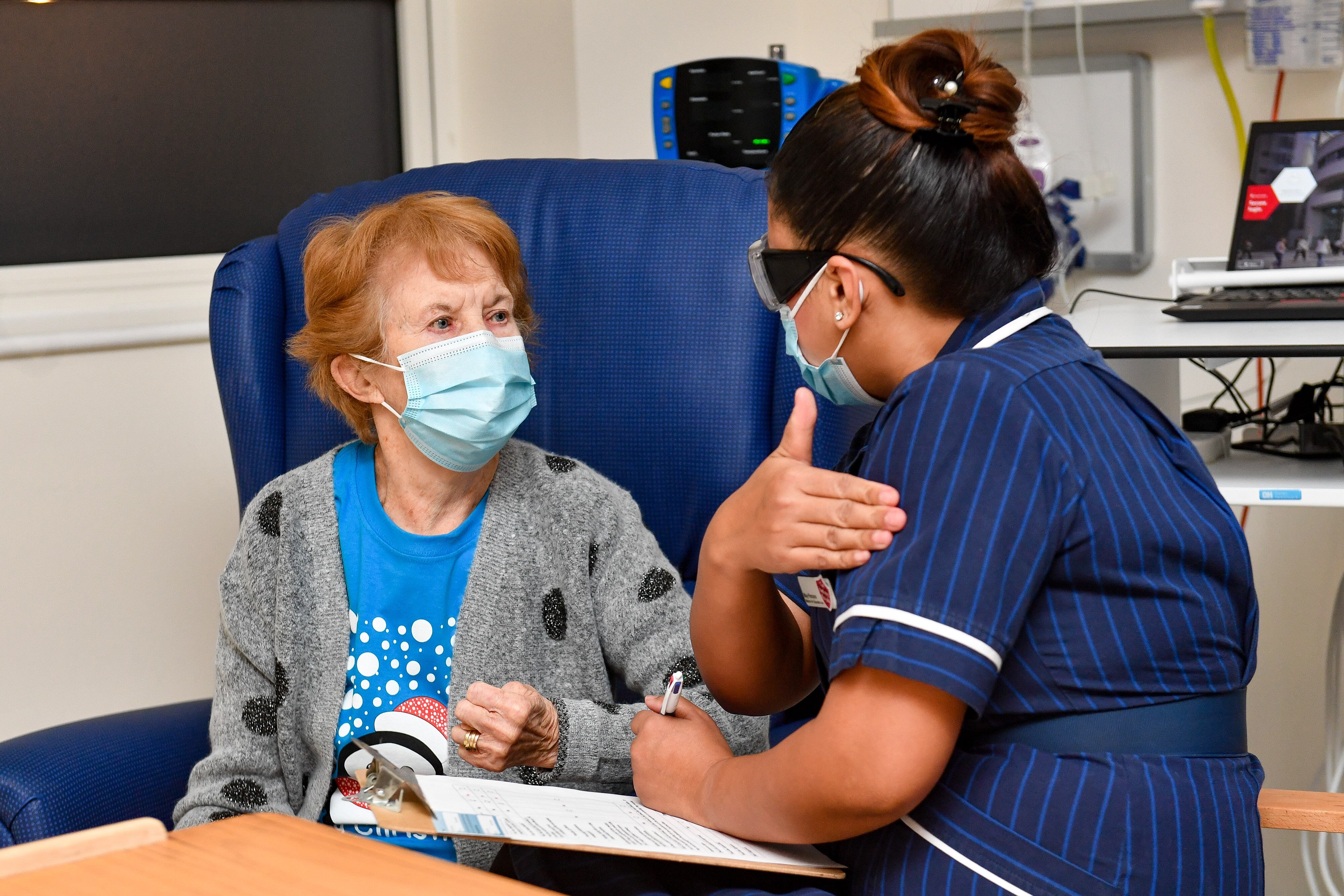 La enfermera May Parsons (R) prepara a Margaret Keenan (L), de 90 años, para ser la primera persona en recibir la vacuna Pfizer / BioNtech Covid-19 en el Hospital Universitario de Coventry, en el centro de Inglaterra, el 8 de diciembre de 2020, cuando Gran Bretaña inicia su mayor evento. programa de inmunización. - Gran Bretaña el 8 de diciembre aclamó un punto de inflexión en la lucha contra la pandemia de coronavirus, ya que comienza el programa de vacunación más grande en la historia del país con un nuevo pinchazo de Covid-19. (Foto de Jacob King / POOL / AFP)