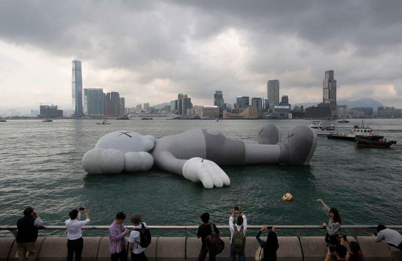 22 de marzo - Fanáticos toman fotografías de "Companion", la escultura flotante del artista estadounidense KAWS, en el paseo marítimo del puerto de Victoria después de la ceremonia de inauguración de su exposición en Hong Kong. FOTO: Kin Cheung/AP