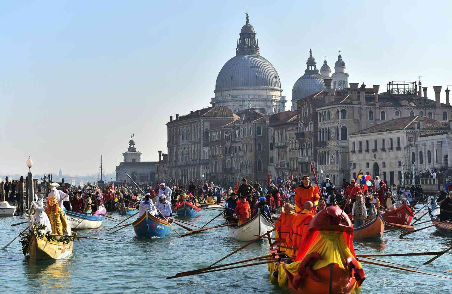 La regata inaugural del Carnaval de Venecia, con sus botes decorados, pasa cerca de la Basílica de Santa María de la Salud, en el Gran Canal. FOTO: Vincenzo PINTO / AFP