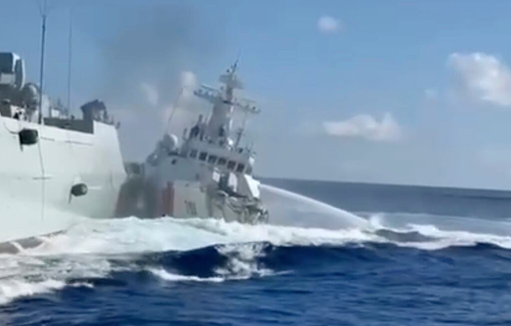 En esta foto, tomada de un video y proporcionada por la Guardia Costera de Filipinas, se ve un barco de la Guardia Costera china dañado, a la derecha, junto a un buque de la Armada china, a la izquierda, después de que chocaran accidentalmente mientras perseguían a un barco pesquero filipino cerca de Scarborough Shoal en el disputado Mar de China Meridional el lunes 11 de agosto de 2025. (Guardia Costera de Filipinas vía AP)