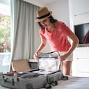 Mujer organizando su equipaje en la habitación del hotel