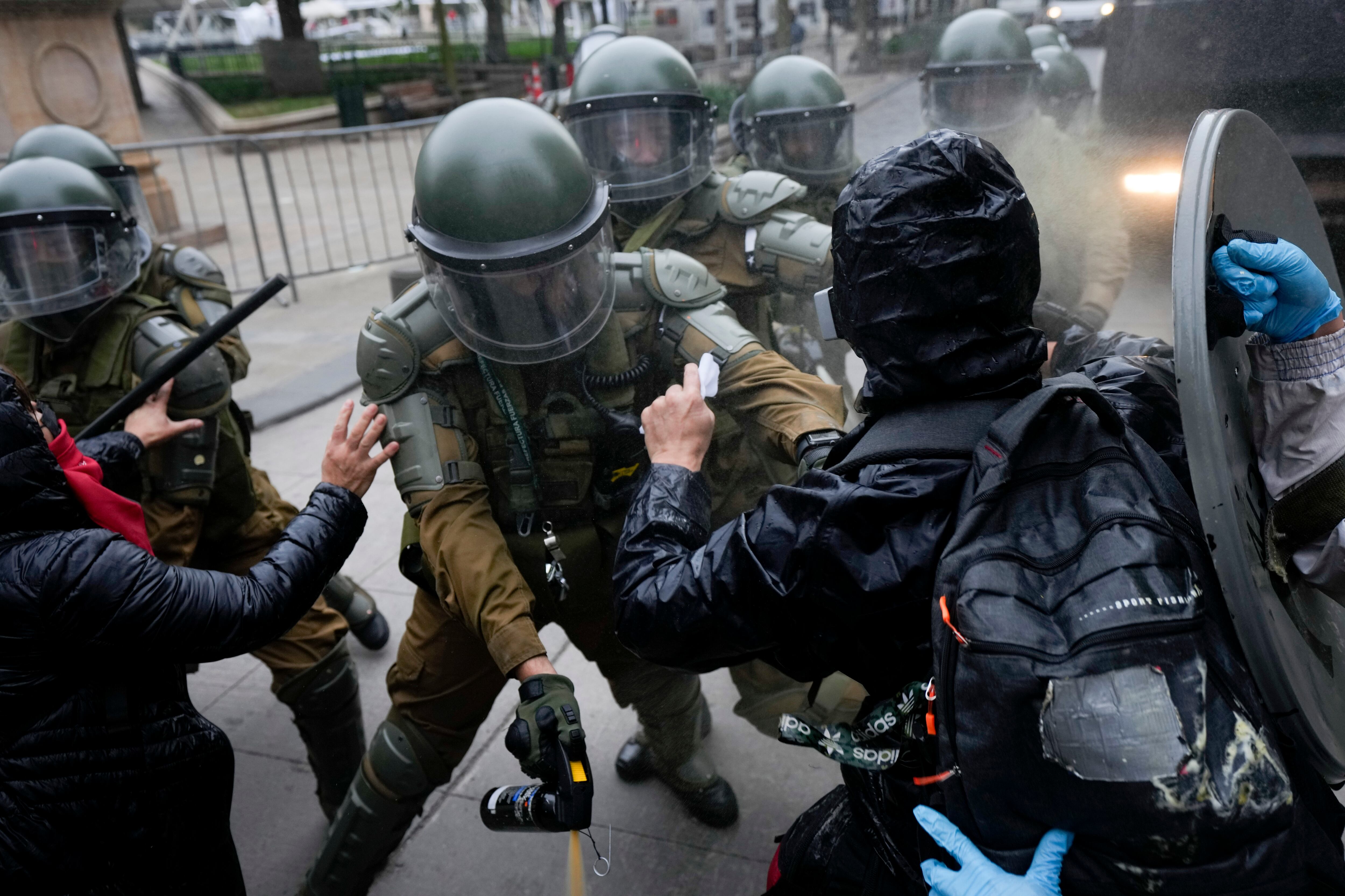 Manifestantes chocan con la policía durante una marcha que conmemora el 50 aniversario de un golpe militar liderado por el general Augusto Pinochet frente al palacio presidencial de La Moneda en Santiago, Chile, el domingo 10 de septiembre de 2023. (Foto AP/Esteban Félix)