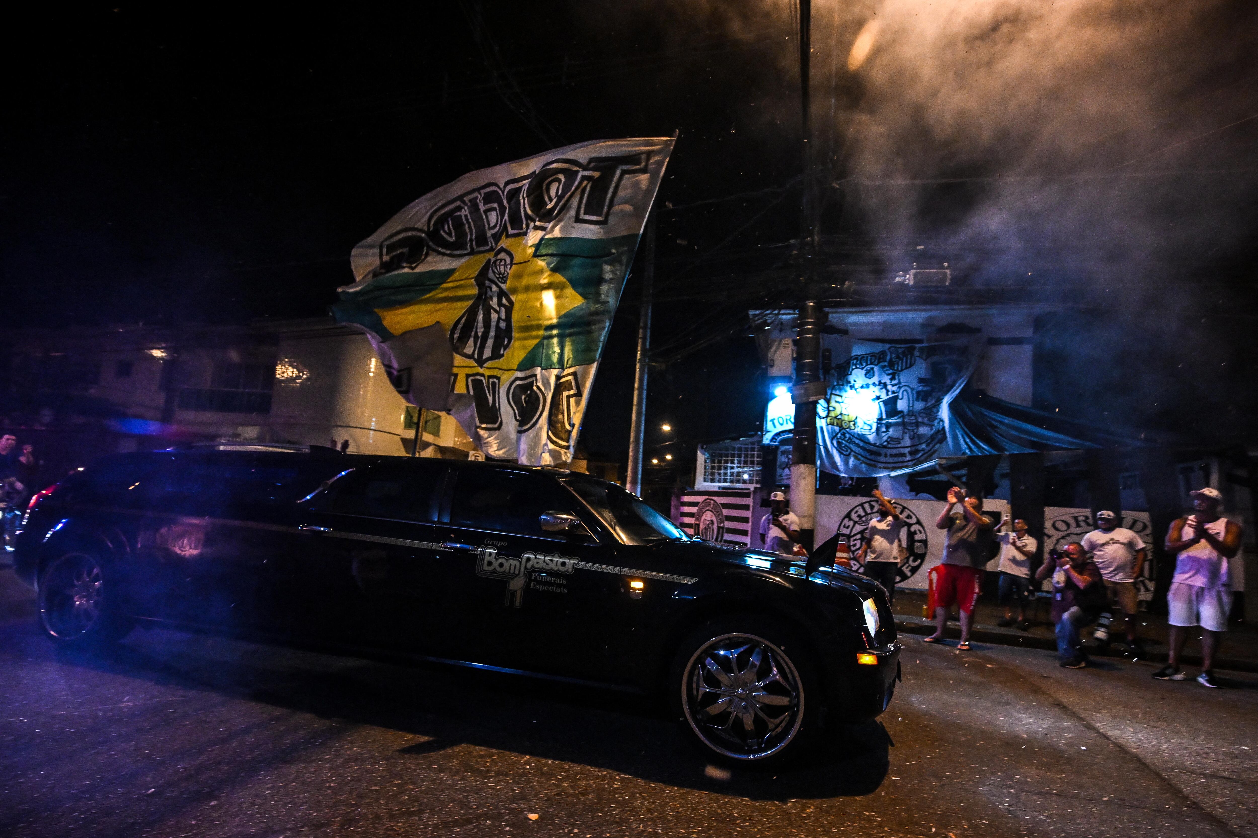 A hearse carrying the coffin of Brazilian football legend Pele arrives at Vila Belmiro stadium as fans mourn his death in Santos on January 2, 2023. - A 24-hour wake for Pele will be held at Vila Belmiro stadium in Santos starting January 2, following by what is expected to be a massive funeral procession through the city before his burial at Santos's Necropole Memorial Cemetery in a private ceremony on January 3. (Photo by NELSON ALMEIDA / AFP)
