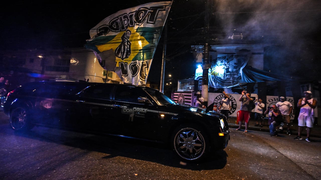 Un coche fúnebre que lleva el ataúd de la leyenda del fútbol brasileño Pelé llega al estadio Vila Belmiro, mientras los fanáticos lloran su muerte en Santos el 2 de enero de 2023