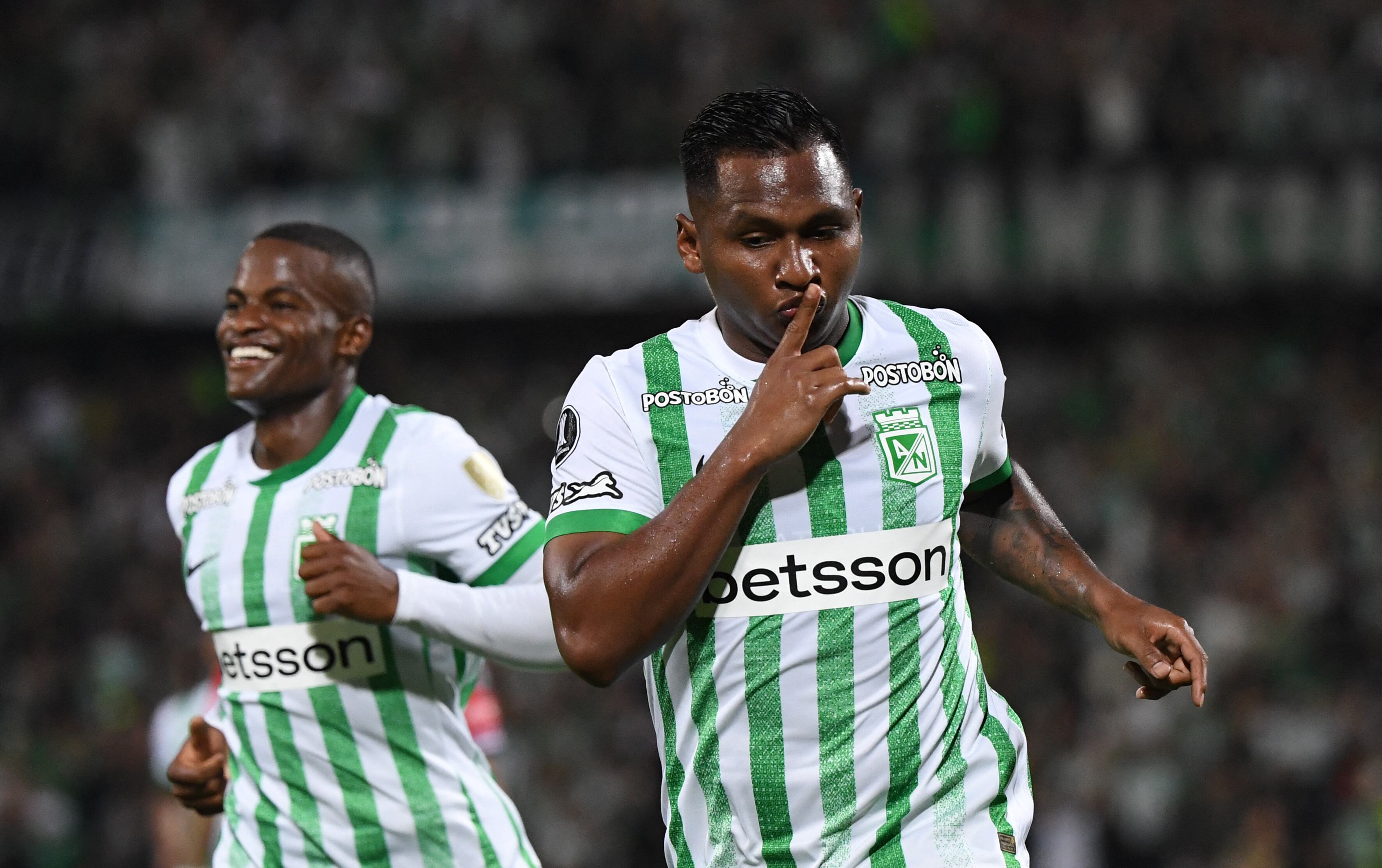 Atletico Nacional's forward #09 Alfredo Morelos (R) celebrates after scoring with teammate defender #06 Andres Roman during the Copa Libertadores group stage first round football match between Colombia's Atletico Nacional and Uruguay's Nacional at the Atanasio Girardot stadium in Medellin, Antioquia department, Colombia, on April 2, 2025. (Photo by Jaime SALDARRIAGA / AFP)