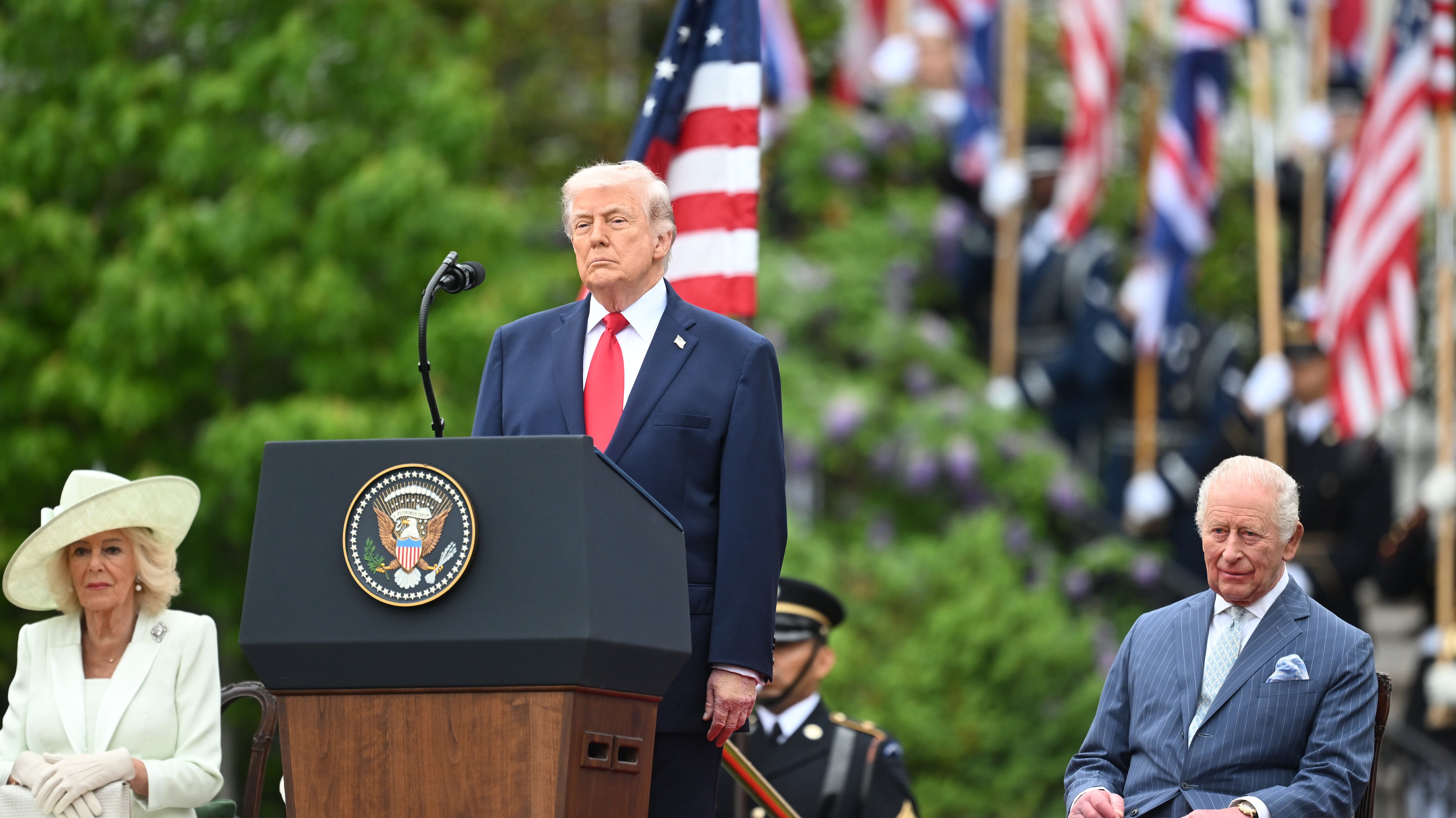 La reina Camila y el rey Carlos III observan mientras el presidente de Estados Unidos, Donald Trump, pronuncia un discurso en el escenario durante una ceremonia de bienvenida en el jardín sur de la Casa Blanca