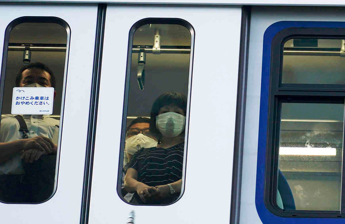 Los pasajeros que usan máscaras faciales para ayudar a frenar la propagación del coronavirus viajan en tren en Tokio. (Foto AP / Eugene Hoshiko)