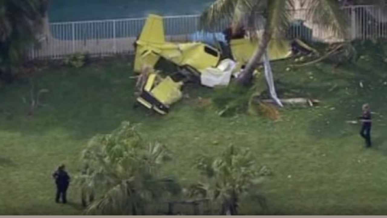 Miembros de los equipos de rescate y buzos de la policía de Coral Springs inspeccionan el estanque mientras se coordina la operación de recuperación y se mantiene el perímetro de seguridad.
