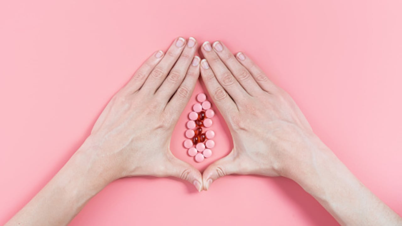 abstract image of female genital organs from hands and pills. concept of women's health and the treatment of female diseases of the urinary tract