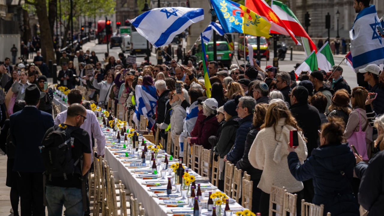 La gente se reúne alrededor de una mesa del Seder vacía con 133 sillas que representan a los rehenes tomados por Hamas el 7 de octubre, durante una protesta frente a Downing Street el 17 de abril de 2024 en Londres, Inglaterra.