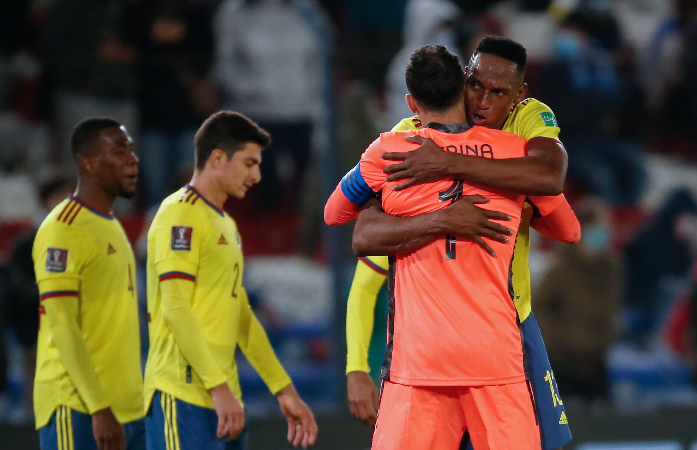 Colombia's Yerry Mina, right, embraces goalkeeper David Ospina at the end of a qualifying soccer match for the FIFA World Cup Qatar 2022 against Uruguay in Montevideo, Uruguay, Thursday, Oct. 7, 2021. The game ended in a 0-0 tie. (Andres Cuenca/Pool via AP)