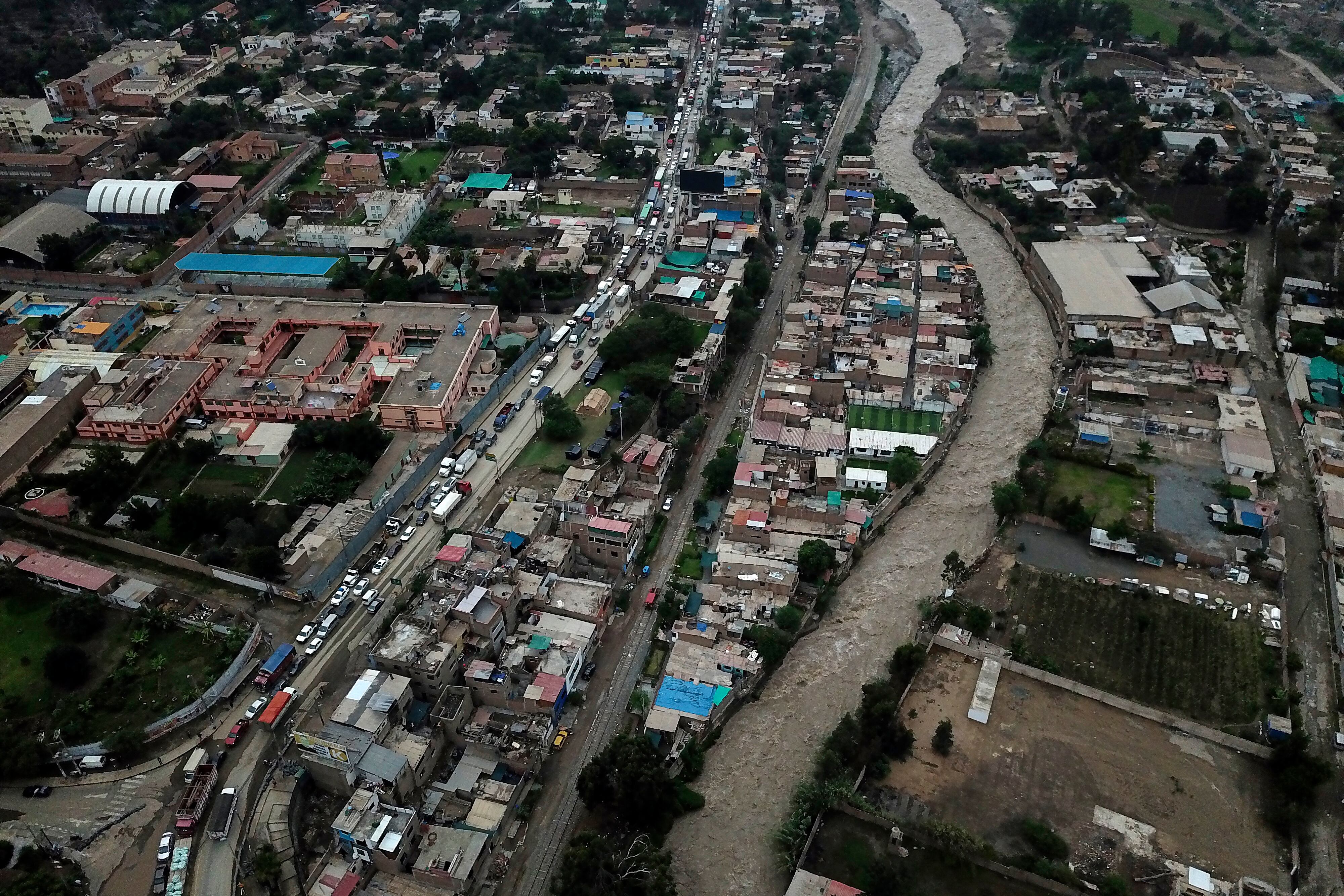 Esta fotografía aérea tomada el 15 de marzo de 2023 muestra camiones y automóviles bloqueando la vía principal de acceso a Lima luego de fuertes lluvias en Chaclacayo, al este de Lima, Perú. - Al menos 59 personas han muerto y más de 12.000 se han visto afectadas por la temporada de lluvias en Perú desde septiembre por inundaciones y desbordamiento de ríos, informó la Defensa Civil el 12 de marzo de 2023. Las inundaciones acompañadas de fuertes vientos que afectan a parte de Perú aumentaron en las últimas 72 horas y afectó zonas urbanas y rurales de los departamentos costeros de Ancash, La Libertad, Lambayeque, Piura y Tumbes, en la frontera con Ecuador. (Foto de Cris BOURONCLE / AFP)