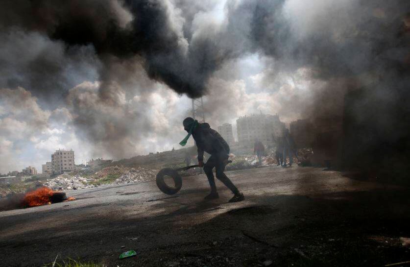 Un manifestante palestino quema una llanta durante un choque con tropas israelíes durante una manifestación en apoyo a los prisioneros palestinos recluidos en cárceles israelíes. FOTO: Majdi Mohammed/AP