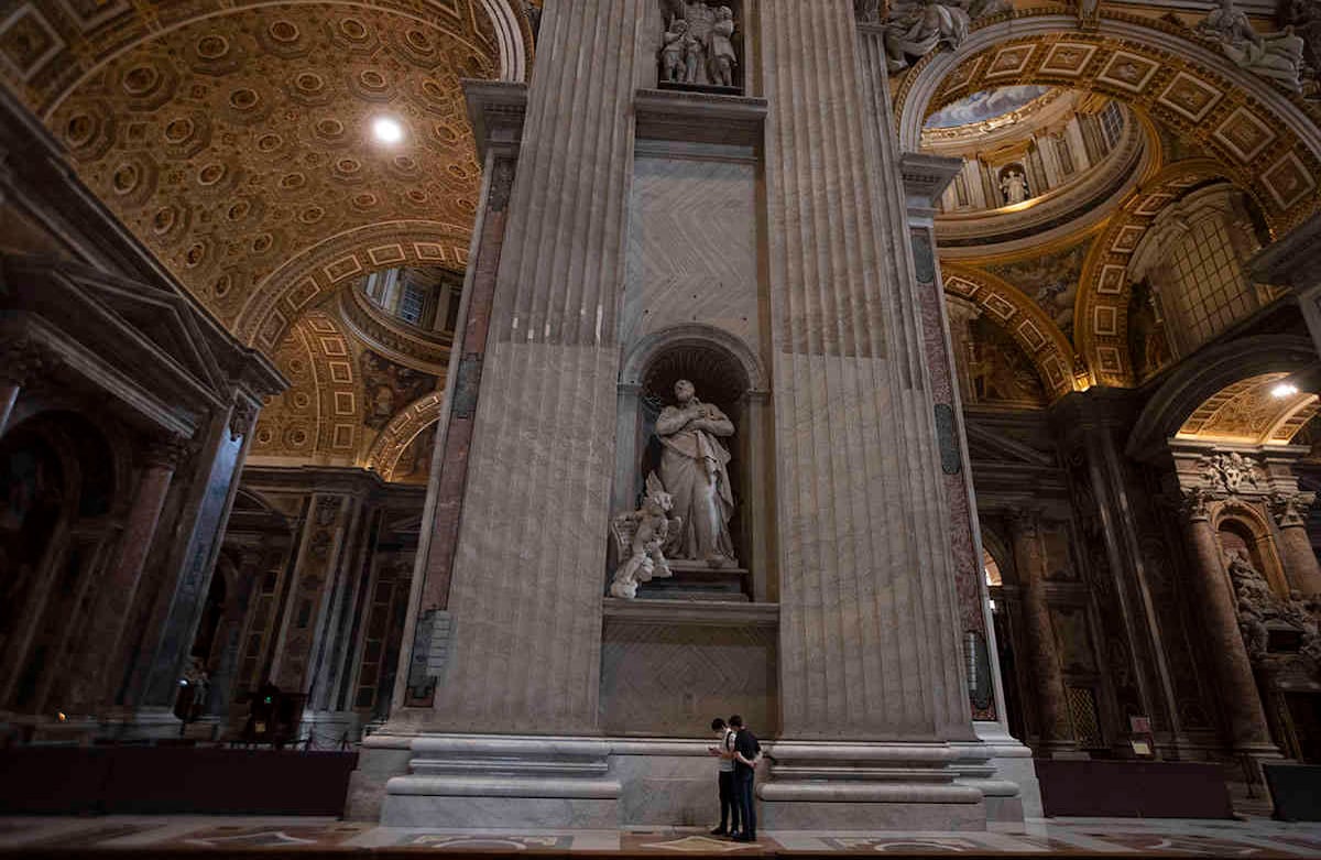 Los visitantes que usan una máscara facial para evitar la propagación de covid-19, caminan en la Basílica de San Pedro en el Vaticano el día de su reapertura, el lunes 18 de mayo de 2020. Italia está levantando lentamente las restricciones sanitarias después de un bloqueo de dos meses contra el coronavirus. . (Foto AP / Alessandra Tarantino)