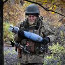 Un soldado ucraniano lleva un proyectil con un mensaje escrito al ejército ruso, en la posición de primera línea cerca de Bakhmut, en la región de Donetsk, Ucrania, el jueves 27 de octubre de 2022.