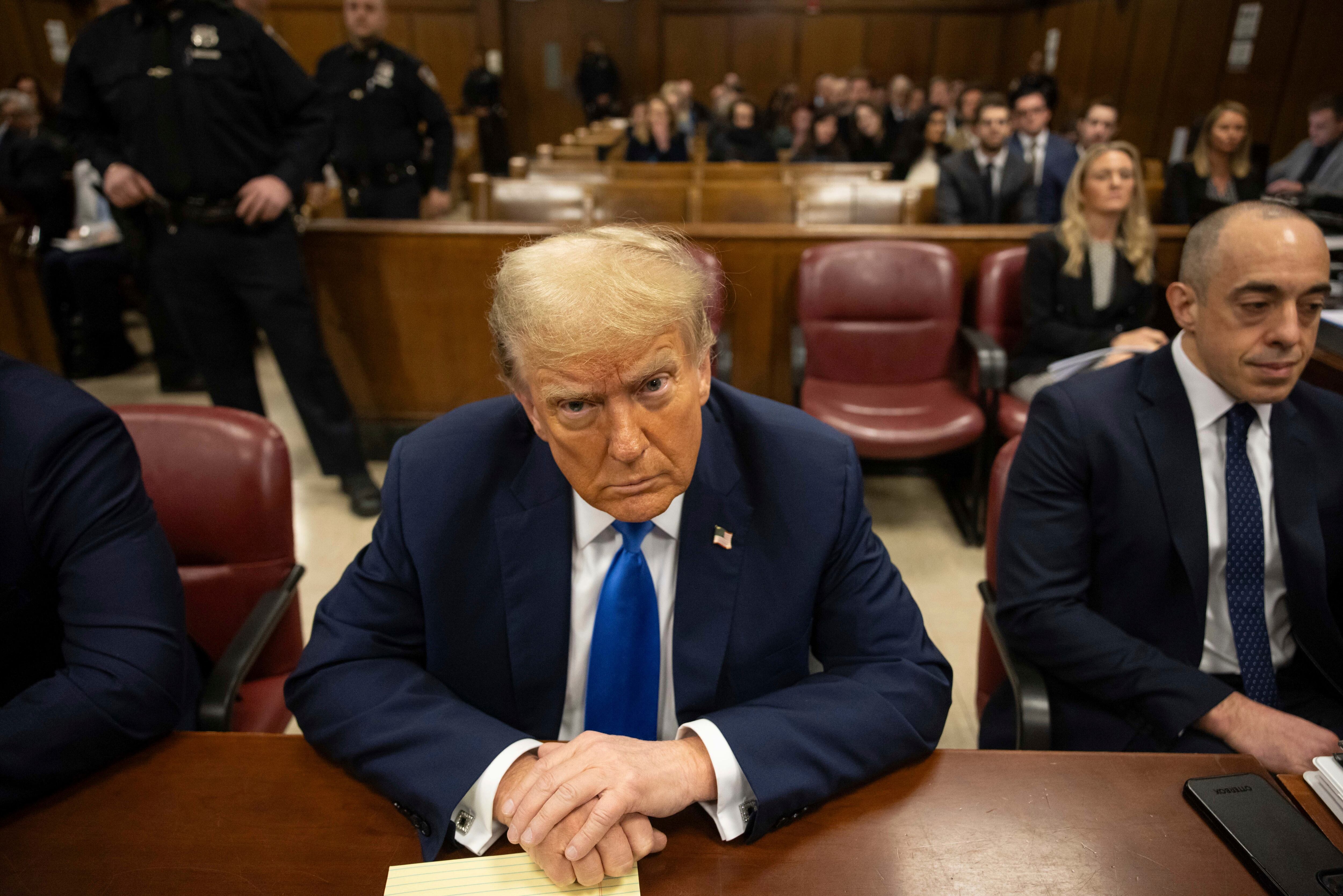 El expresidente Donald Trump, en el centro, espera el inicio del procedimiento en el tribunal penal de Manhattan, el lunes 22 de abril de 2024, en Nueva York.