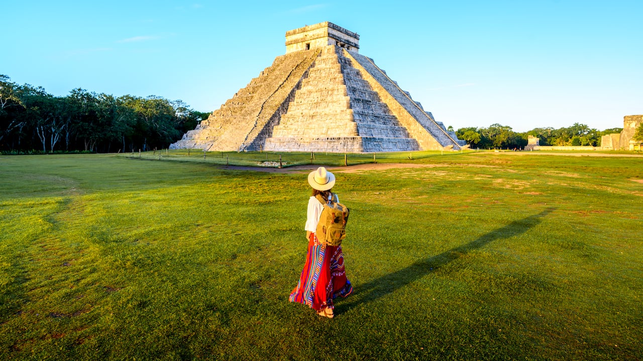 Mujer admirando el Templo de Kukulcán (El Castillo) en Chichén Itzá, Yucatán, México.
