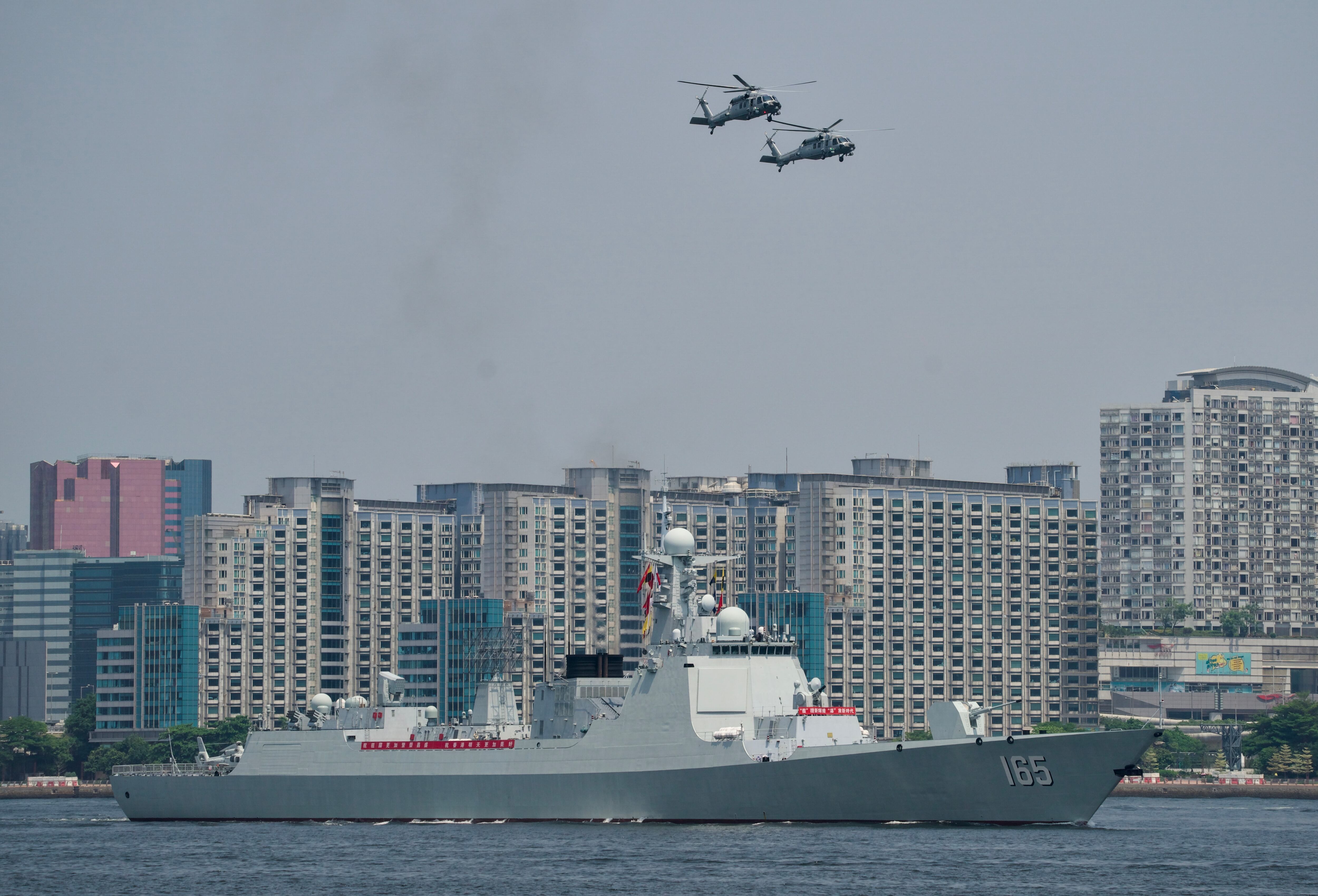 Un ciudadano ondea la bandera nacional de China mientras la gente despide a la flota de la Armada del Ejército Popular de Liberación (EPL) liderada por el portaaviones Shandong el 7 de julio de 2025 en Hong Kong, China. (Foto de Li Peiyun/VCG vía Getty Images)