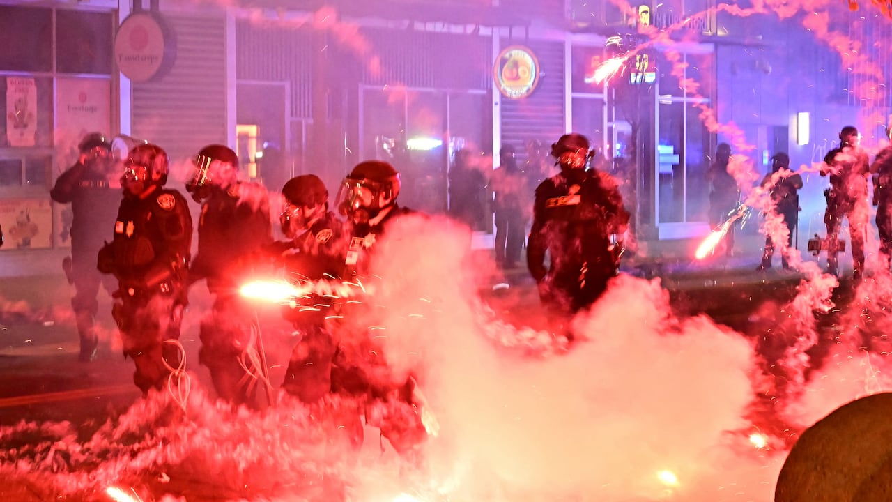 Fuegos artificiales estallan alrededor de policías antidisturbios durante una protesta en respuesta a los operativos federales de inmigración en el barrio de Little Tokyo, en el centro de Los Ángeles, el 9 de junio de 2025.