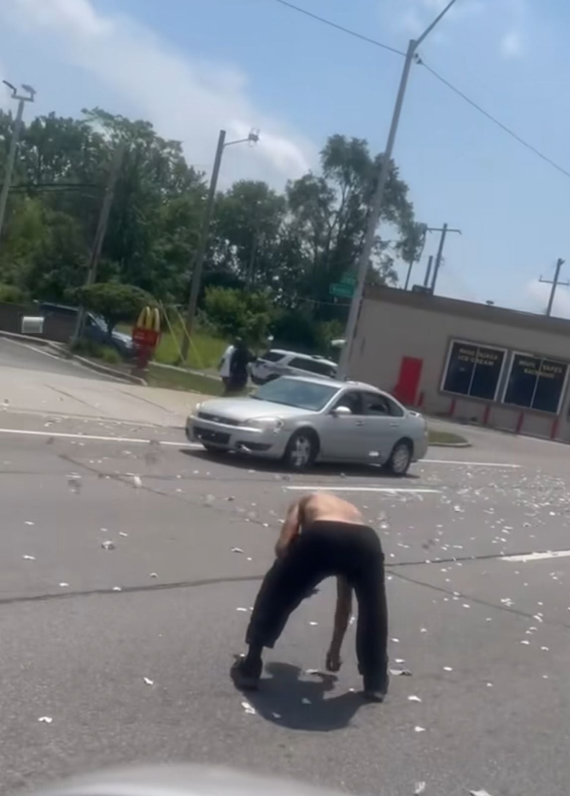 Un hombre recoge billetes arrojados por un helicóptero en Detroit