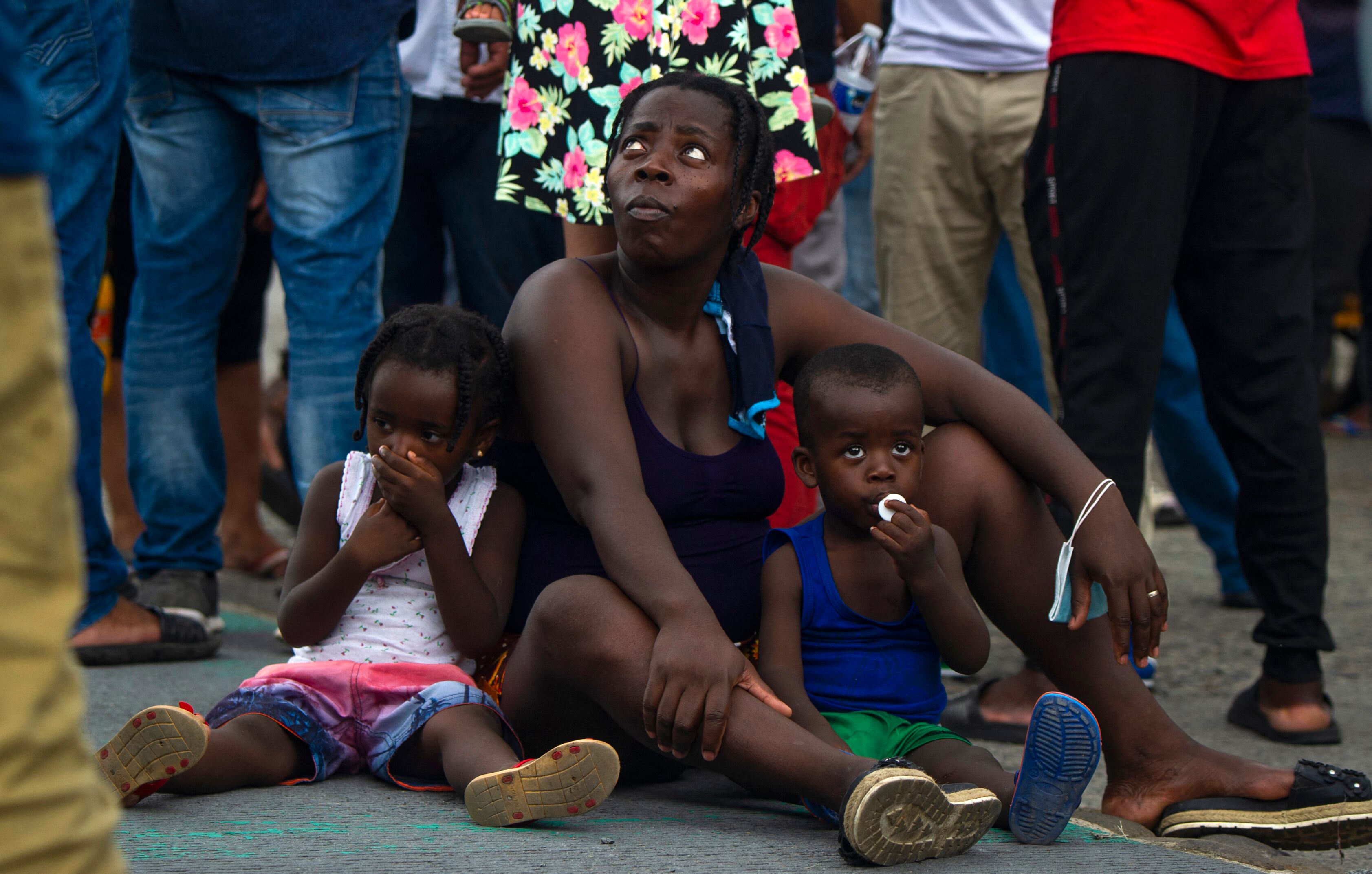 A Haitian migrant woman and her children remain in the main square of Tapachula, Chiapas state, Mexico, on September 14, 2021. - Tens of thousands of US-bound migrants stranded in an overcrowded city in southern Mexico are desperate to escape what they say feels like a huge open-air prison. (Photo by CLAUDIO CRUZ / AFP)