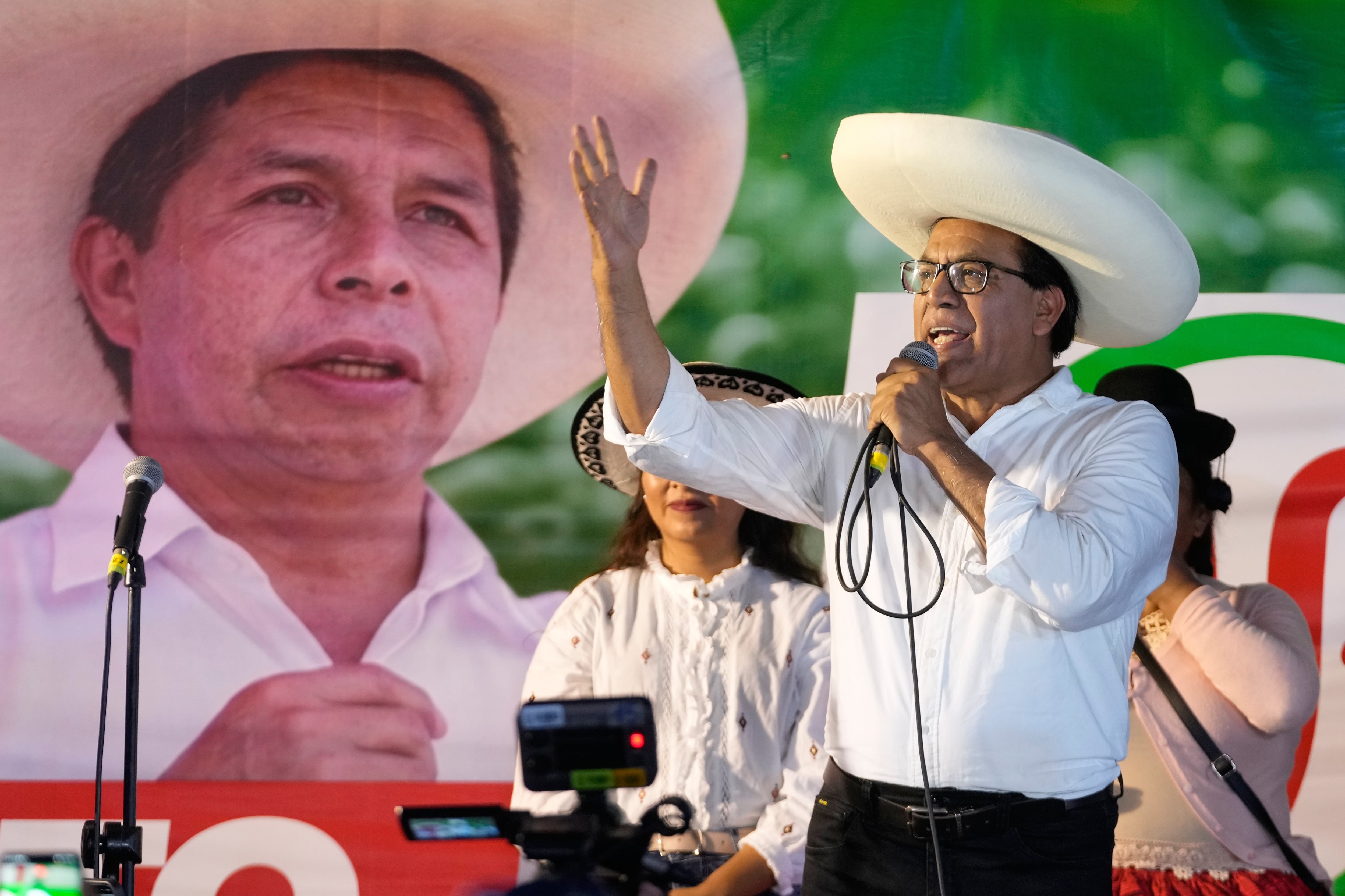 El candidato presidencial Roberto Sánchez, del partido Juntos por el Perú, pronuncia un discurso con una pancarta del expresidente Pedro Castillo de fondo.