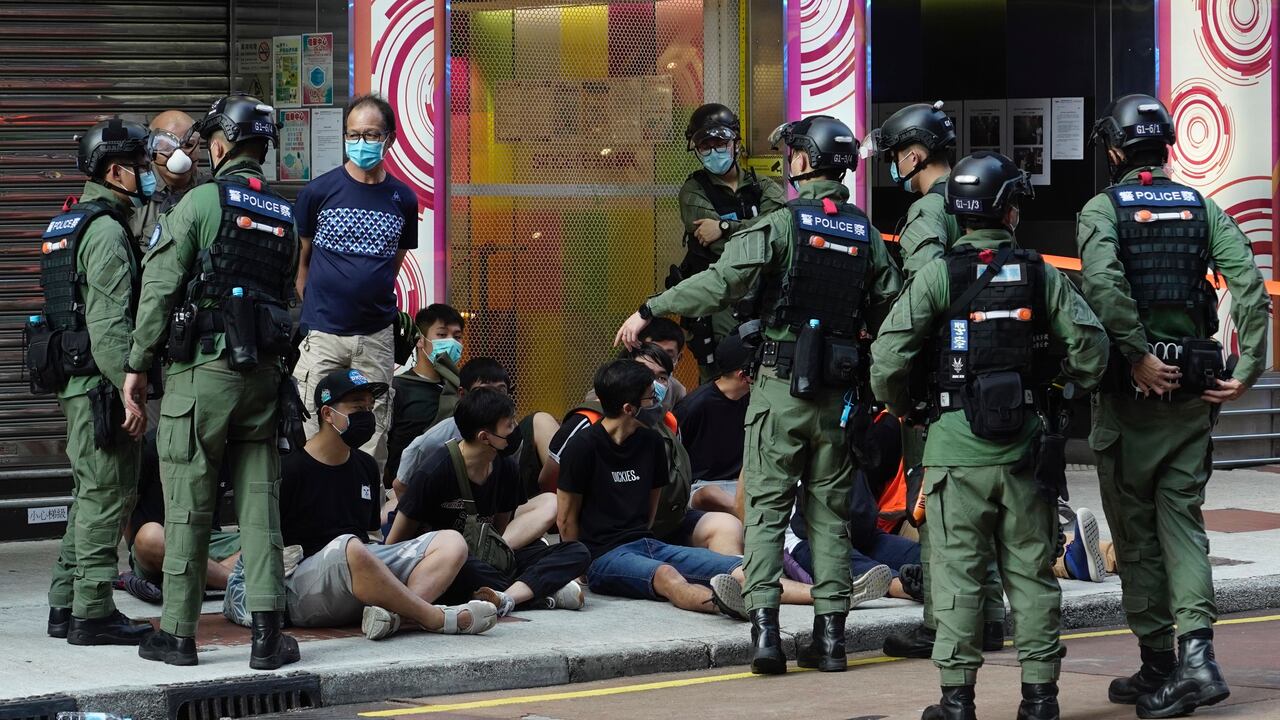 People, sitting on the ground, are arrested by police officers at a downtown street in Hong Kong Sunday, Sept. 6, 2020. About 30 people were arrested Sunday at protests against the government's decision to postpone elections for Hong Kong's legislature, police and a news report said. (AP Photo/Vincent Yu)