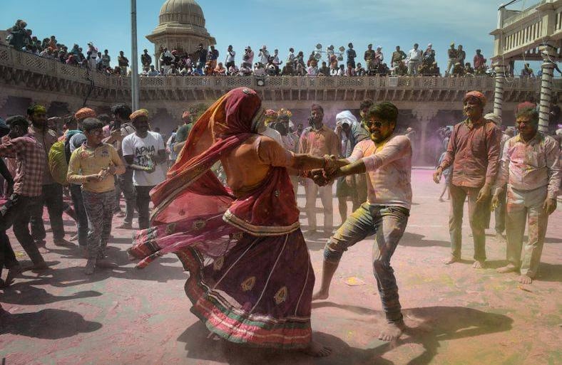 Los devotos hindúes cubiertos en polvo de colores bailan a las afueras de un templo. Holi celebra el triunfo del bien sobre el mal del que se habla en varias leyendas hindúes. FOTO: Noemi Cassanelli / AFP.